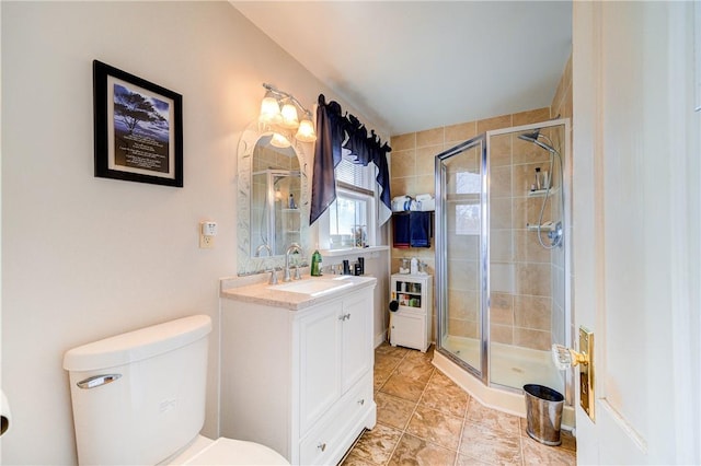 bathroom with toilet, an enclosed shower, and vanity