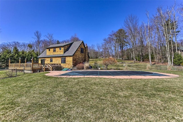 view of pool featuring a lawn and a deck