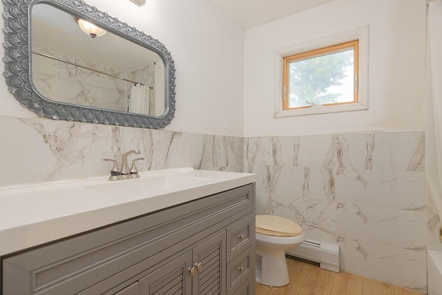 4 Newport Dr, Nanuet, NY 10954 - full bath featuring a baseboard radiator, toilet, vanity, tile walls, and wainscoting
