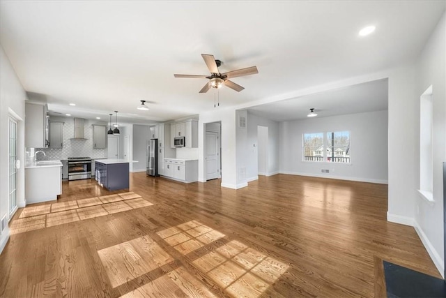 unfurnished living room featuring light hardwood / wood-style floors and ceiling fan