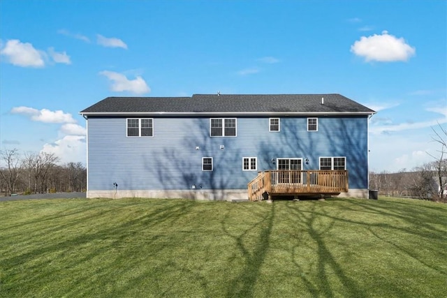 back of property featuring a wooden deck and a yard