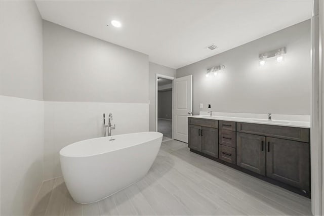 bathroom with a washtub and vanity