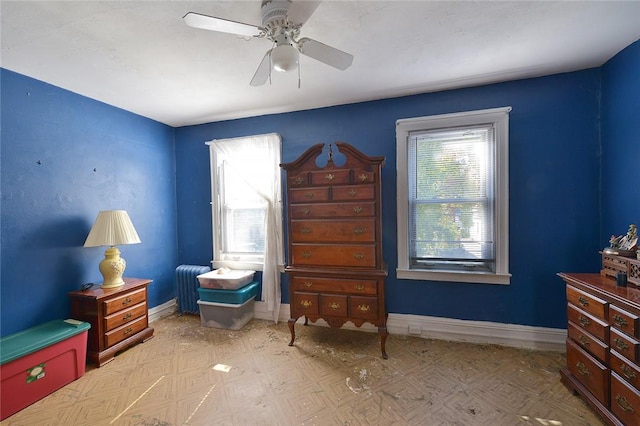 sitting room with radiator heating unit, plenty of natural light, and ceiling fan