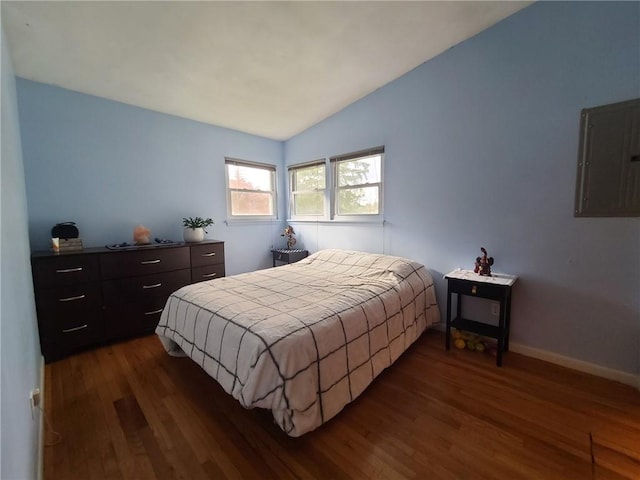 bedroom with dark hardwood / wood-style flooring, electric panel, and vaulted ceiling