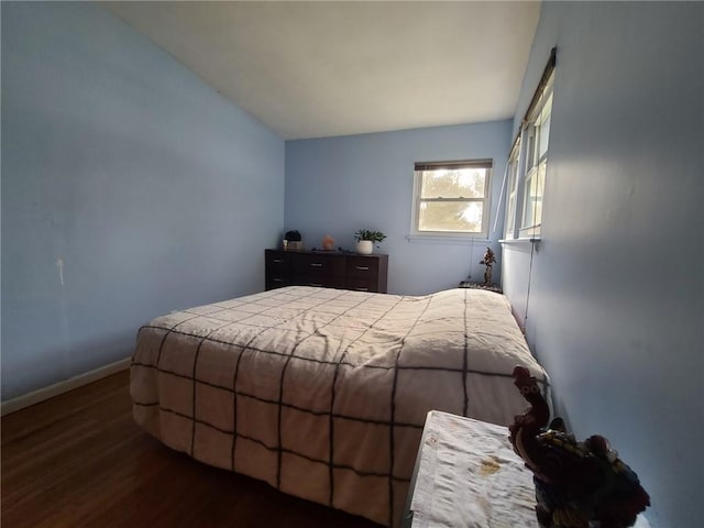 bedroom with dark hardwood / wood-style flooring