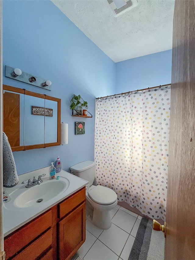 bathroom with tile patterned floors, toilet, a textured ceiling, vanity, and curtained shower