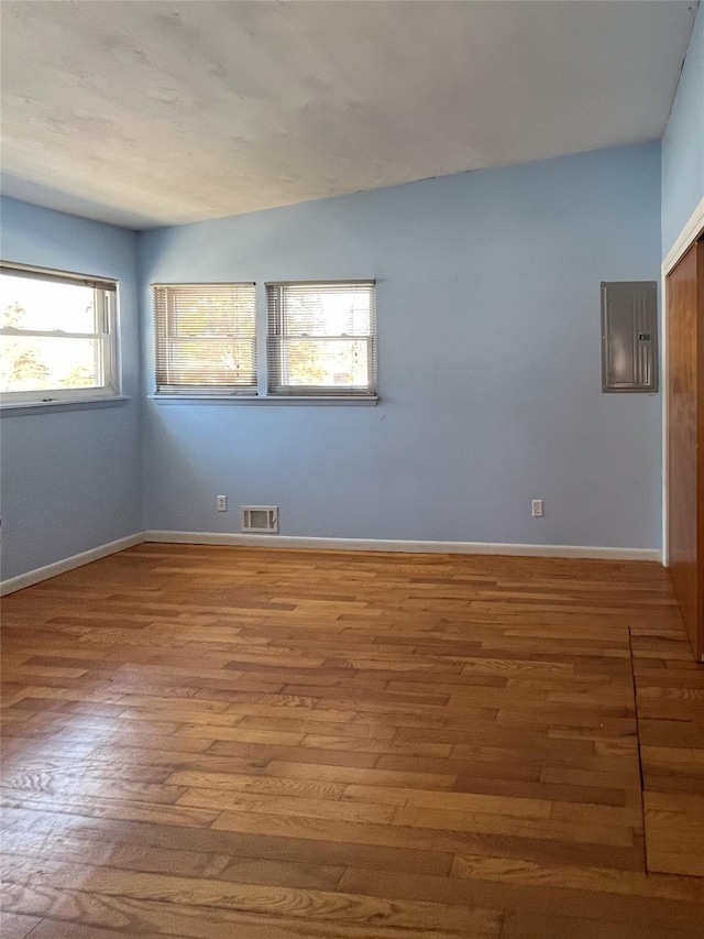 empty room featuring hardwood / wood-style flooring and electric panel