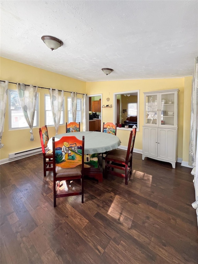 dining space with dark wood-type flooring, a textured ceiling, and baseboard heating