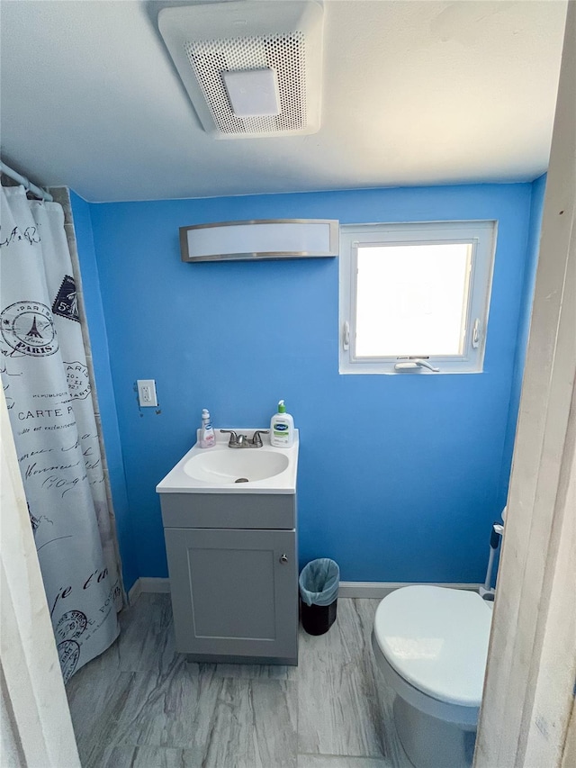 bathroom featuring vanity, toilet, and curtained shower