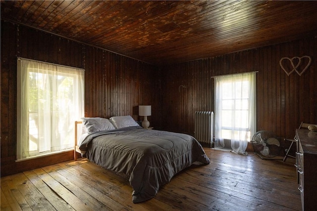 24921 State Highway 97, Hancock, NY 13783 - bedroom with dark hardwood / wood-style floors, radiator, wooden ceiling, and wood walls