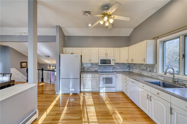 kitchen with lofted ceiling, white appliances, white cabinets, sink, and light wood-type flooring