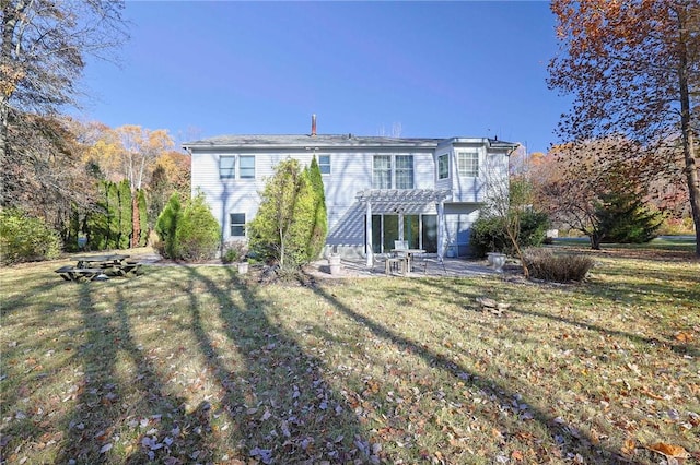 back of house featuring a pergola, a patio area, and a lawn