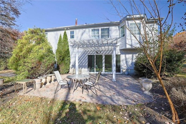 back of property with a pergola and a patio area