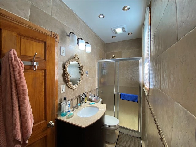 bathroom featuring an enclosed shower, vanity, toilet, and tile walls