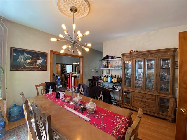 dining space featuring hardwood / wood-style floors and an inviting chandelier