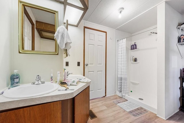 bathroom with a shower with curtain, vanity, and hardwood / wood-style flooring