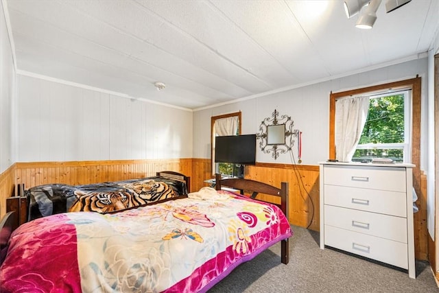 bedroom with ornamental molding, light colored carpet, and wooden walls