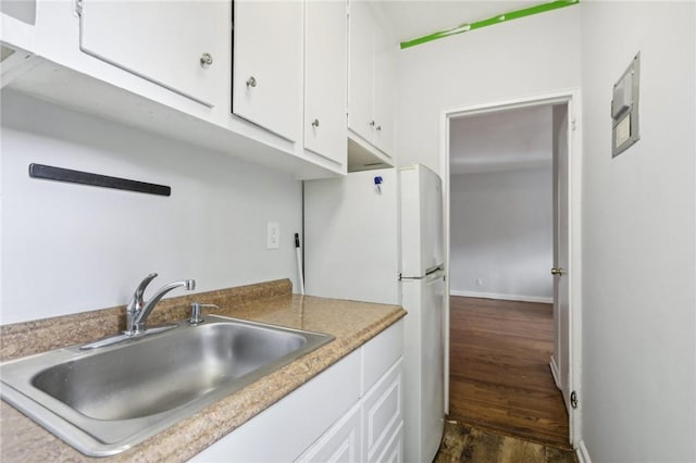 kitchen featuring white cabinets, dark hardwood / wood-style floors, white fridge, and sink