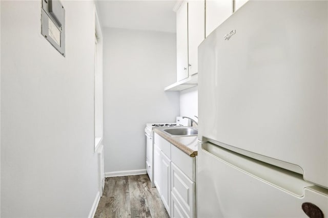 laundry room with light wood-type flooring and sink