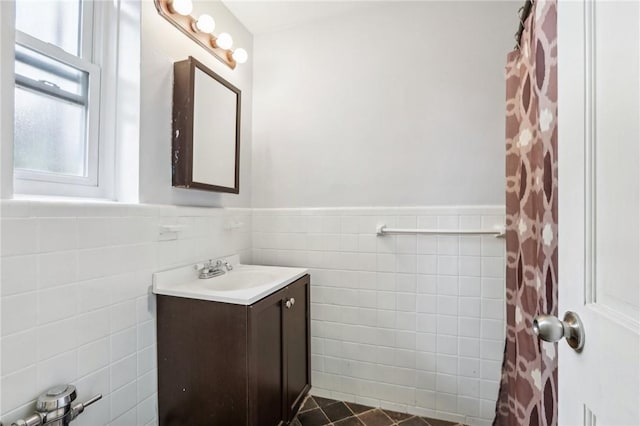 bathroom with tile patterned flooring, vanity, and tile walls