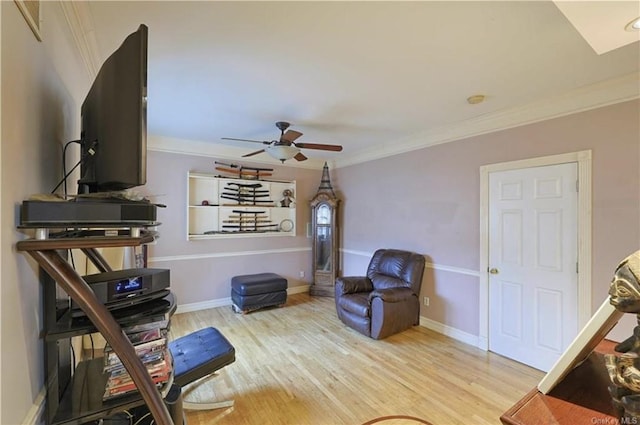 living area with crown molding, ceiling fan, and light hardwood / wood-style floors