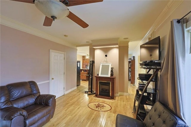 living room featuring light wood-type flooring, ceiling fan, and crown molding