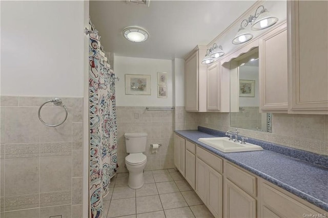 bathroom featuring vanity, a shower with curtain, tile patterned flooring, toilet, and tile walls