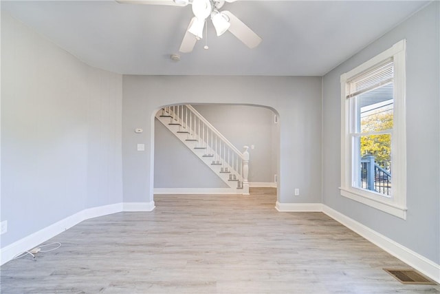 empty room with ceiling fan and light hardwood / wood-style floors