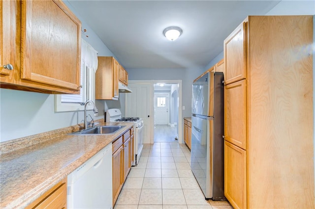 kitchen featuring light tile patterned floors, white appliances, and sink