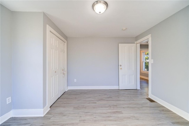 unfurnished bedroom with a closet and light hardwood / wood-style floors