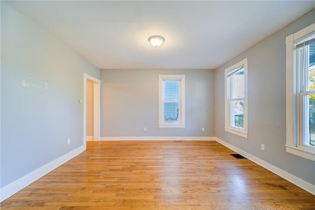 unfurnished room featuring a healthy amount of sunlight and light wood-type flooring