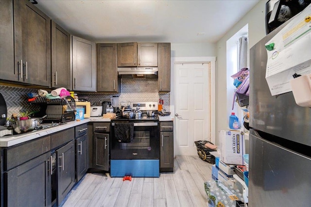 kitchen with dark brown cabinetry, stainless steel appliances, and tasteful backsplash