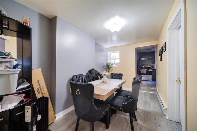 dining space featuring light hardwood / wood-style flooring and baseboard heating