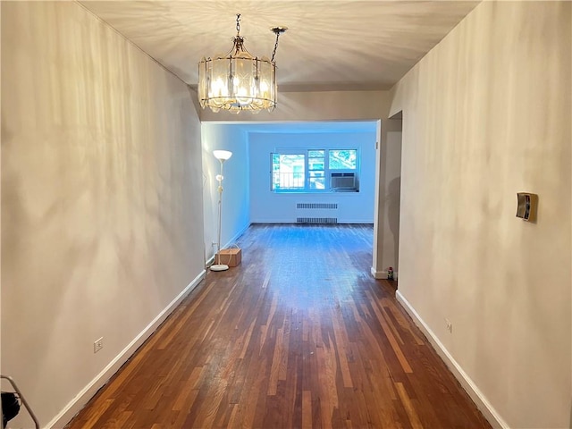 hall with cooling unit, dark wood-type flooring, radiator, and an inviting chandelier