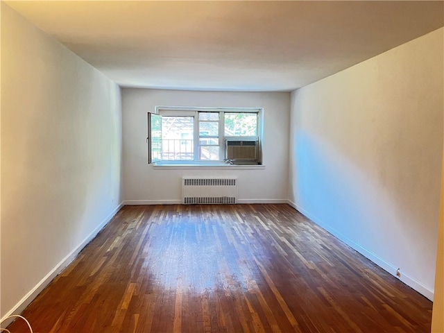 spare room featuring radiator heating unit, dark hardwood / wood-style floors, and cooling unit