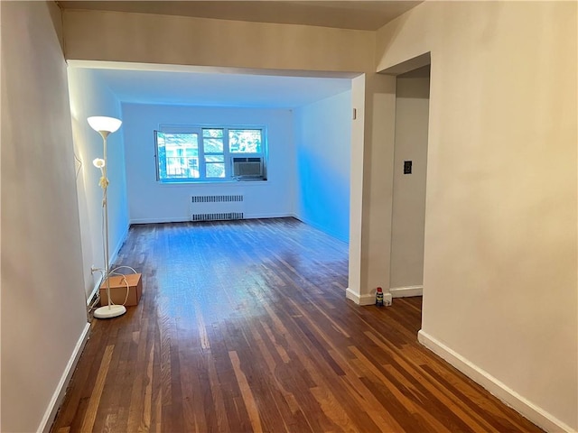 hall with radiator heating unit, cooling unit, and dark hardwood / wood-style floors