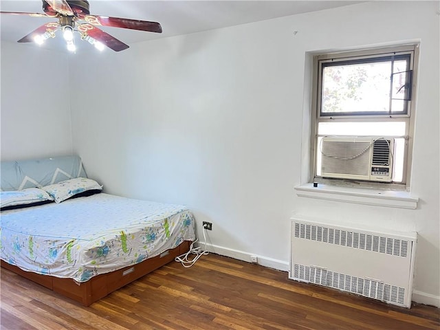 bedroom featuring dark hardwood / wood-style floors, radiator, cooling unit, and ceiling fan