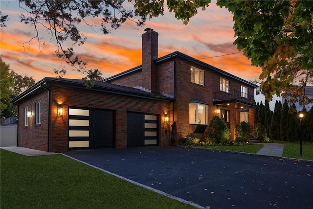 view of front of home with a lawn, a balcony, and a garage