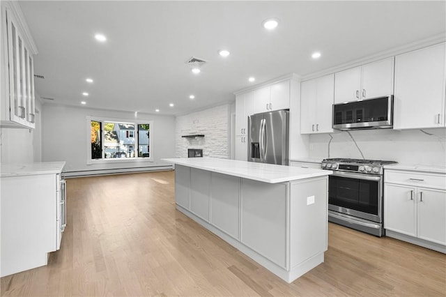 kitchen featuring a center island, white cabinets, stainless steel appliances, and light hardwood / wood-style flooring