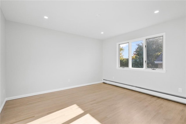 empty room featuring light hardwood / wood-style flooring and a baseboard heating unit