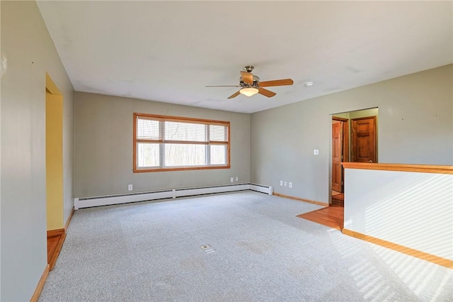 unfurnished room with light carpet, ceiling fan, and a baseboard heating unit