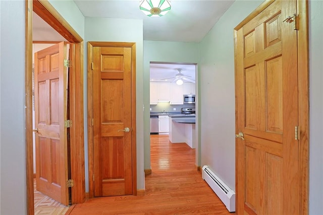 corridor featuring light hardwood / wood-style flooring and a baseboard heating unit