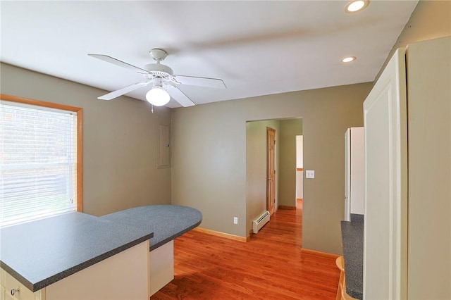 kitchen featuring white cabinets, dark hardwood / wood-style floors, a baseboard radiator, and ceiling fan