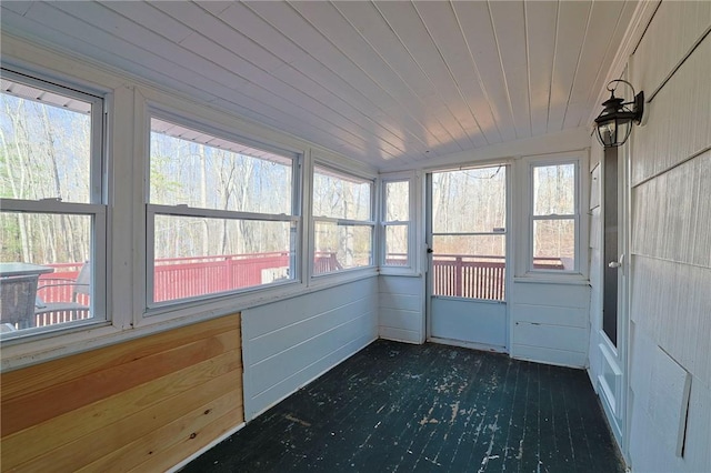 unfurnished sunroom featuring vaulted ceiling, plenty of natural light, and wood ceiling