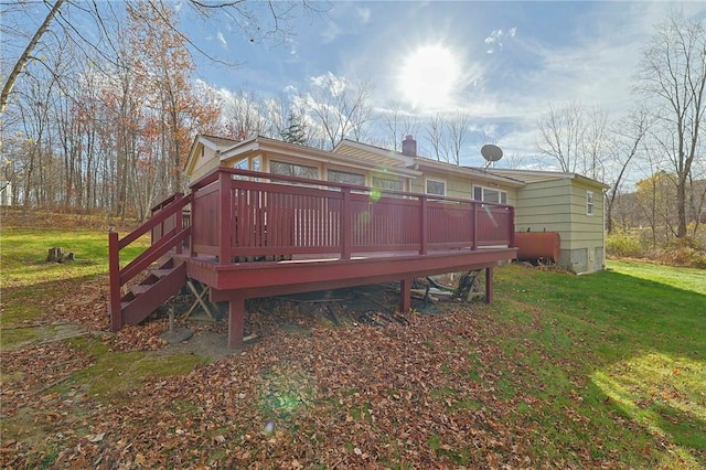 rear view of house featuring a lawn and a deck