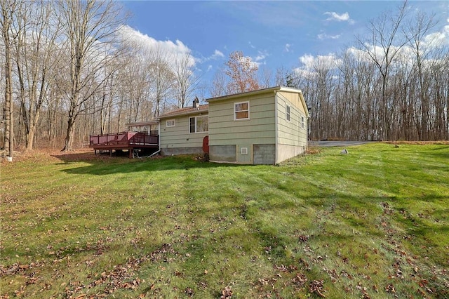 back of house featuring a deck and a lawn