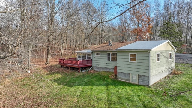back of property with a deck and a lawn