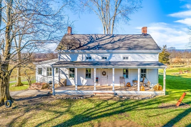 back of house featuring covered porch and a yard