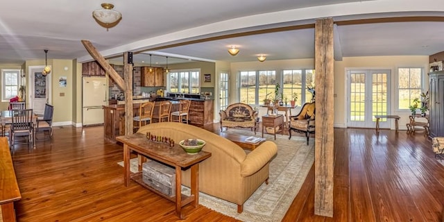 living room featuring beam ceiling, french doors, and hardwood / wood-style flooring