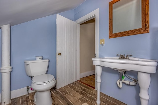 bathroom featuring wood-type flooring and toilet